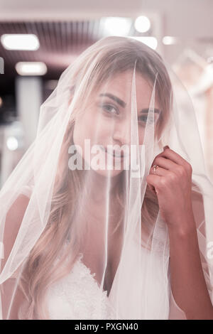 Pleasant nice young woman touching her veil Stock Photo