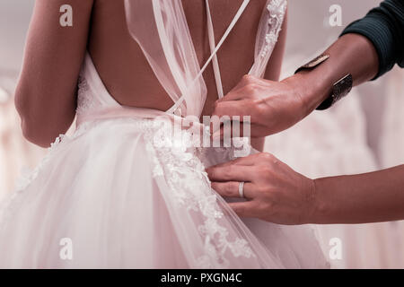 Close up of a wedding dress being fastened Stock Photo
