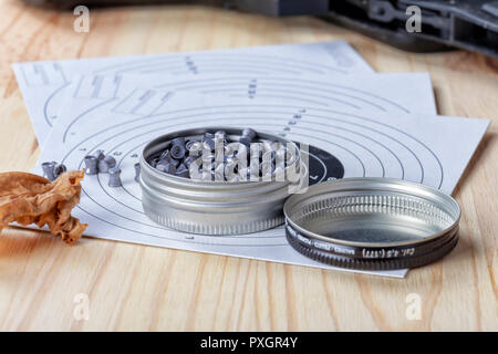 A box of lead shot for shotguns on top of cardboard targets. Stock Photo