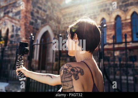 Female vlogger filming her daily video diary outdoors. Woman creating social media content. Stock Photo