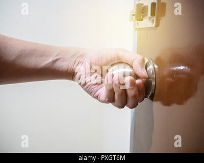 Close up of hand holding a door knob, opening or closing the door. Stock Photo