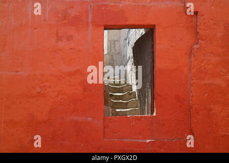 Doorway on the red stone wall leading to the staircase inside an old building in Monastery of Santa Catalina, Arequipa, Peru Stock Photo