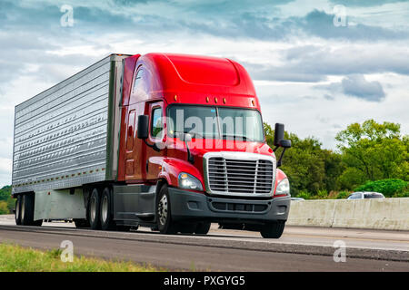 Horizontal shot of a red semi-truck on an interstate highway. Stock Photo