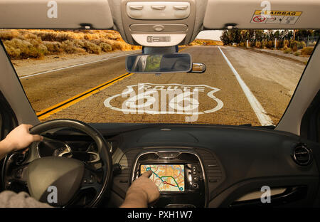 Driving a car while using the touch screen of a GPS navigation system on the Historic Route 66 in California, USA Stock Photo