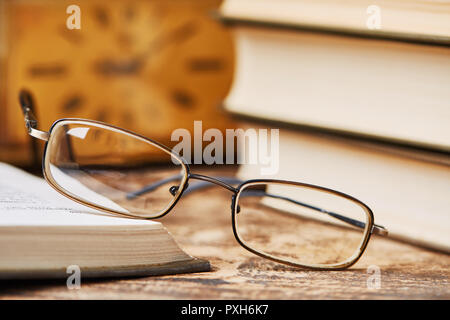 The glasses are lying on a bookcase of wooden shelves Stock Photo