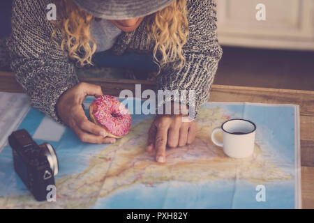 Hipster young lady doing breakfast and planning the next trip vacation travel tour. long blonde hair and alternative lifestyle for people. traveling a Stock Photo