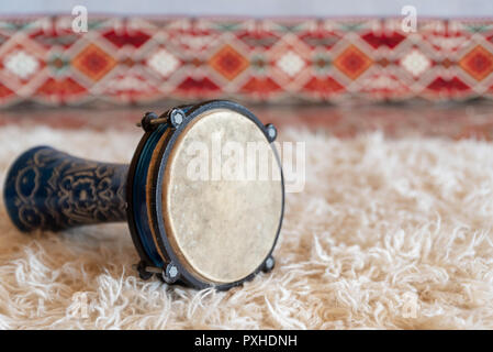 Traditional drum on white carpet Stock Photo