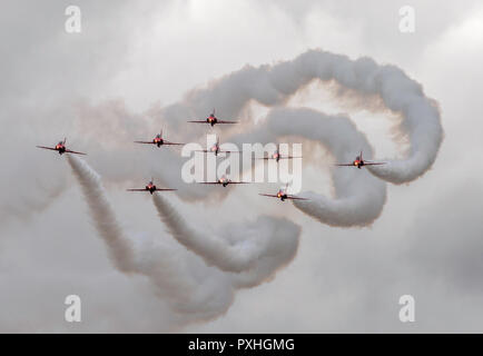 Nine Red Arrows Royal Airforce aerobatic display team with white smoke trails in flight over Highclere Castle, Berkshire, England Stock Photo