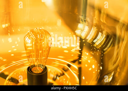 Glowing modern yellow lamp made of glass close Stock Photo