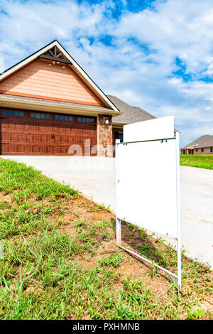 Vertical shot of a blank real estate sign in front of new home construction. Stock Photo