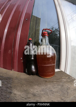 Plastic Wine Bottles Stand in the courtyard on the windowsill Stock Photo