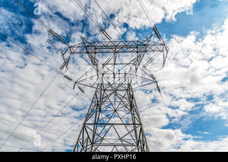 Horizontal shot of a High Voltage Tower and Power Lines under cloudy skies. Stock Photo