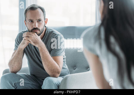 cropped shot of unhappy middle aged man looking at young girlfriend, relationship difficulties concept Stock Photo