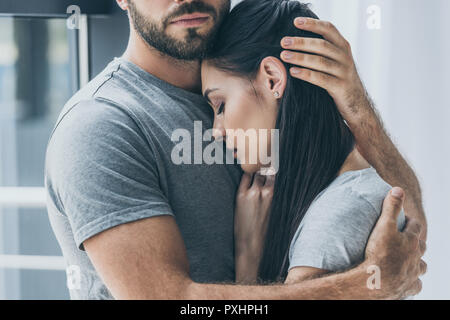 cropped shot of bearded man hugging and supporting young sad woman Stock Photo