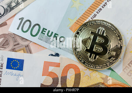 Physical version of Bitcoin, new virtual money . Golden symbolic coin of bitcoin on Euro banknotes. Exchange bitcoin. Concept worldwide cryptocurrency Stock Photo