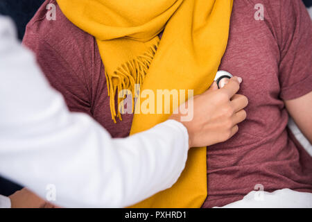 cropped shot of female doctor using stethoscope to listen to patients breath Stock Photo