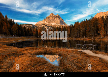 Antorno lake during late autumn with red leaves and tre cime reflection. Italy, Dolomites, Europe