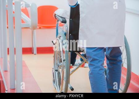 Child on the Wheelchair in the Hospital Hall. Healthcare Theme. Stock Photo