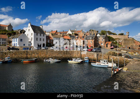 Stone ramp and pier walls at Crail Harbour with fishing boats and lobster traps in Crail Fife Scotland UK Stock Photo
