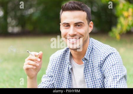 Man smoking a cigarette outdoors Stock Photo