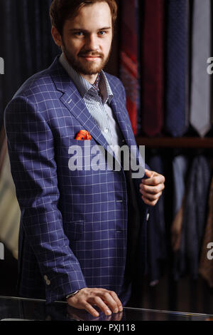 Elegant man in fashion suit and hat posing at atelier with beverage Stock Photo