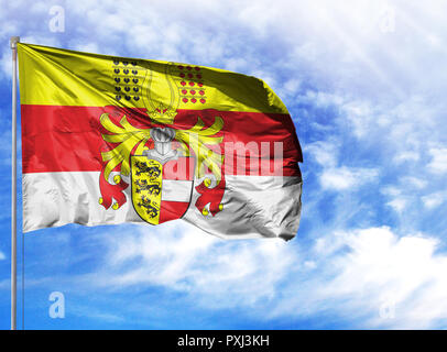 National flag of Carinthia on a flagpole in front of blue sky. Stock Photo