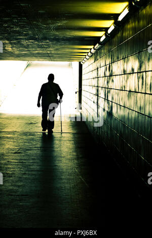Light at the end of the tunnel. Silhouette of a figure standing at ... Silhouette Man Walking Tunnel