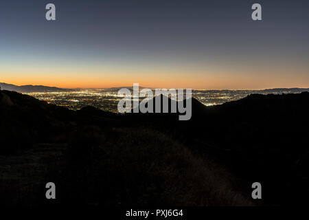 Los Angeles California predawn view of hilltop ridgeline above the San Fernando Valley.  Burbank, North Hollywood and the San Gabriel Mountains are in Stock Photo