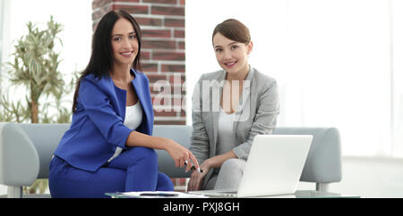 Smiling businesswomen discussing over tablet PC in office Stock Photo
