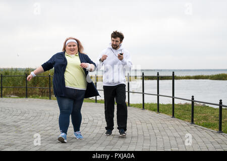 Obese Woman Running in Park Stock Photo