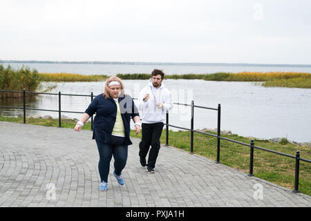 Overweight Woman Running in Park Stock Photo