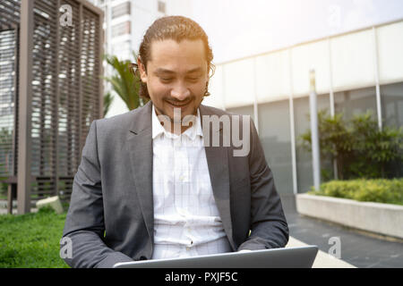middle eastern business man using laptop outdoor Stock Photo