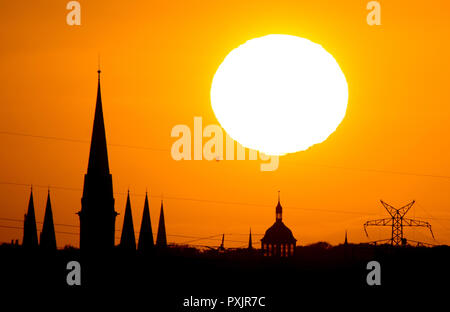 Oldenburg, Germany. 22nd Oct, 2018. The sun goes down over the Lamberti church and bathes the silhouette of the city in a warm light. Credit: Hauke-Christian Dittrich/dpa/Alamy Live News Stock Photo