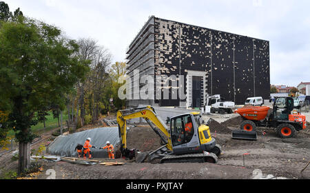 Weimar, Germany. 23rd Oct, 2018. Builders are working on and around the construction of the new Bauhaus Museum (in the background), which is scheduled to open next year. On the same day, the Thuringian State Chancellery and the Ministry of Economics will present the state's cultural and tourist activities as well as its campaign for the Bauhaus year 2019. In 1919 Walter Gropius founded the legendary art and architecture school in Weimar. Even today, the Bauhaus continues to inspire architects, designers and artists worldwide. Credit: Martin Schutt/dpa-Zentralbild/dpa/Alamy Live News Stock Photo