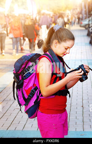 Back view of a hipster girl with backpack walking on Prague city street ...