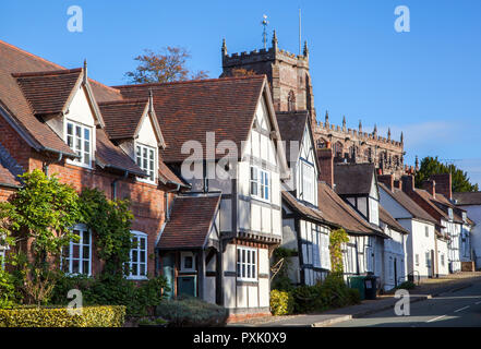 The South Cheshire market town of Malpas with black and white half timbered houses and buildings with St Oswald's parish church in the background Stock Photo