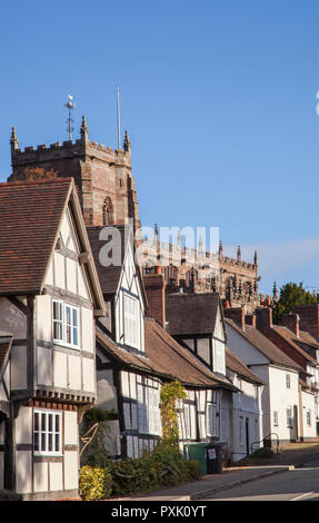 The South Cheshire market town of Malpas with black and white half timbered houses and buildings with St Oswald's parish church in the background Stock Photo