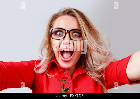 Excited blonde woman taking selfie in studio Stock Photo