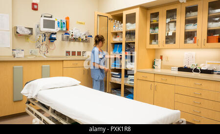 A hospital emergency room nurse stocks a cabinet with trauma supplies. Stock Photo