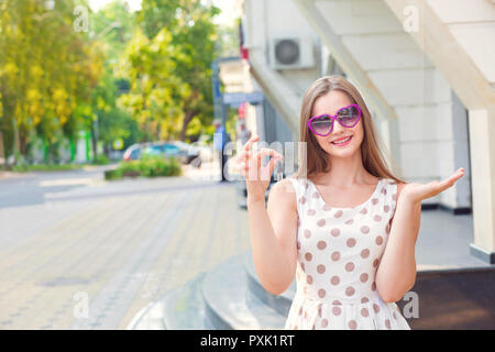Smiling girl holding keys showing the building. Stock Photo