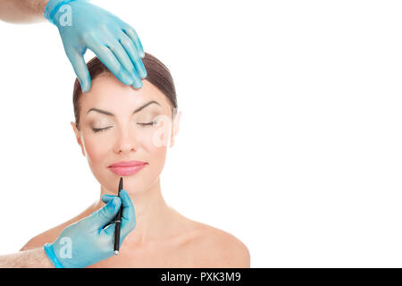 Doctor hands holding face about to draw lines with marker on lips. Stock Photo