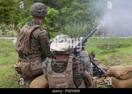 Cpl. John Glomba, left, and Pfc. Luis Steponovich, both  with Weapons Company, Battalion Landing Team, 3rd Battalion, 5th Marines, 31st Marine Expeditionary Unit, fire a .50-caliber Browning machine gun during training at Camp Schwab, Okinawa, Japan, June 1, 2017. Glomba is a dismount squad leader and Steponovich is a machine gunner. The M2, sometimes called the “Ma Deuce,” is the oldest machine gun currently in the Marine Corps’ arsenal.  BLT 3/5 is currently deployed as the Ground Combat Element of the 31st Marine Expeditionary Unit. Weapons Company is the heavy-weapons elements of BLT 3/5.  Stock Photo