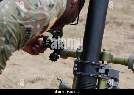 U.S. Army Spc. Jaron Frierson attached to the Headquarters and Headquarters Troop, 2nd Cavalry Regiment, lays in a 81 mm mortar system before a mortar range at the Bemowo Piskie Training Area, Bemowo Piskie, in Poland, on June 6, 2017. The Saber Strike exercise facilitates cooperation and improves joint operational capability in a variety of missions and prepare the participating nations and units for future operations while enhancing the NATO alliance. Stock Photo