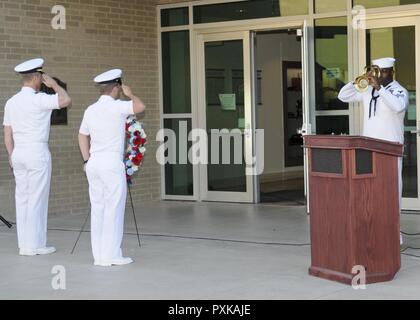 SAN ANTONIO (June 6, 2017) Capt. Brent Kelln, left, Navy Medicine Training Support Center (NMTSC) commanding officer, and Chief Hospital Corpsman Alexander Bransdorf, assigned to NMTSC, salute the ceremonial wreath while Hospital Corpsman 1st Class Adlrin Augustus, of NMTSC, plays taps during a commemoration of the 75th Anniversary of the Battle of Midway at the Medical Education and Training Campus on board Joint Base San Antonio - Fort Sam Houston, Texas. Stock Photo