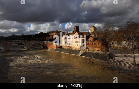 Winter in Rome. River is swollen along Tiber Island embankments under stormy clouds Stock Photo