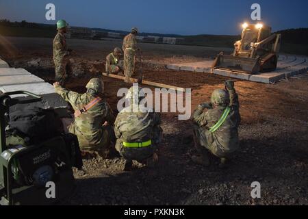 Soldiers from the 465th Company, 926th Engineer Battalion, 926th Engineer Brigade, United States Army Reserves, test and level the base layer for the approach lane to an ammunition-loading dock at the Joint National Training Center, Cincu, Romania, as part of Resolute Castle 2017. Resolute Castle is an exercise strengthening the NATO alliance and enhancing its capacity for joint training and response to threats within the region. Stock Photo