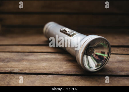 close up old metal flashlight on wooden background Stock Photo