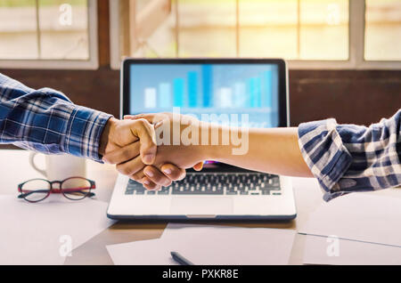 businesspeople shaking hands to seal a deal with his partner  in office. Teamwork , hipster tone Stock Photo