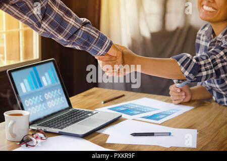 businesspeople shaking hands to seal a deal with his partner  in office. Teamwork , hipster tone Stock Photo