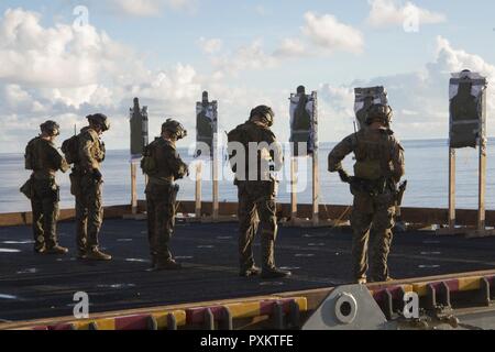 Marines with the 31st Marine Expeditionary Unit’s Force Reconnaissance Platoon (FRP) prepare for marksmanship training aboard the USS Bonhomme Richard (LHD 6), June 15, 2017. FRP and the Amphibious Reconnaissance Platoon form the 31st MEU’s Maritime Raid Force, which specializes in reconnaissance operations from the sea. The 31st MEU partners with the Navy’s Amphibious Squadron 11 to form the amphibious component of the Bonhomme Richard Expeditionary Strike Group. The 31st MEU and PHIBRON 11 combine to provide a cohesive blue-green team capable of accomplishing a variety of missions across the Stock Photo